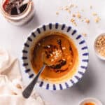 Peanut sauce with chili oil in a blue and white bowl.