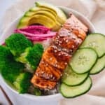 Closeup of pan-fried salmon in teriyaki glaze in a veggie bowl.