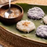 Palitaw on a banana leaf with toasted sesame seeds on top.