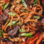 Glossy udon noodles coated in soy-based sauce with steak & veggies.