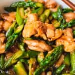 Easy chicken asparagus stir-fry with chopsticks.