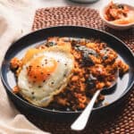 Tuna kimchi fried rice on a blue plate with a fried egg.