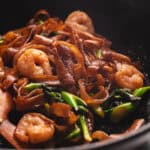Shrimp pad see ew cooking in a large wok.