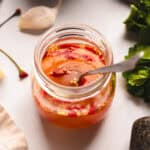 Nuoc cham in a glass mason jar on a white counter.