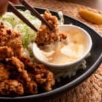 Crispy karaage dipped in japanese mayo with wooden chopsticks.
