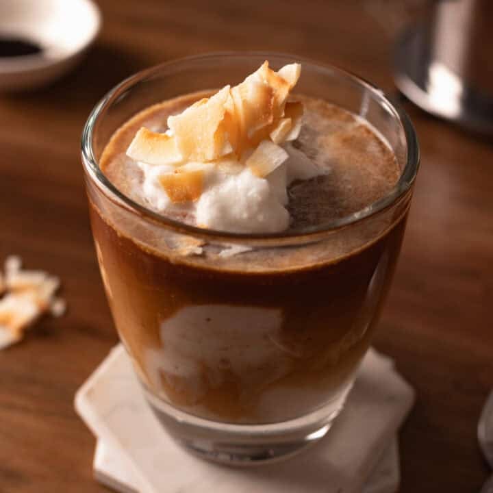 Vietnamese coconut coffee in a glass cup with coconut flakes.