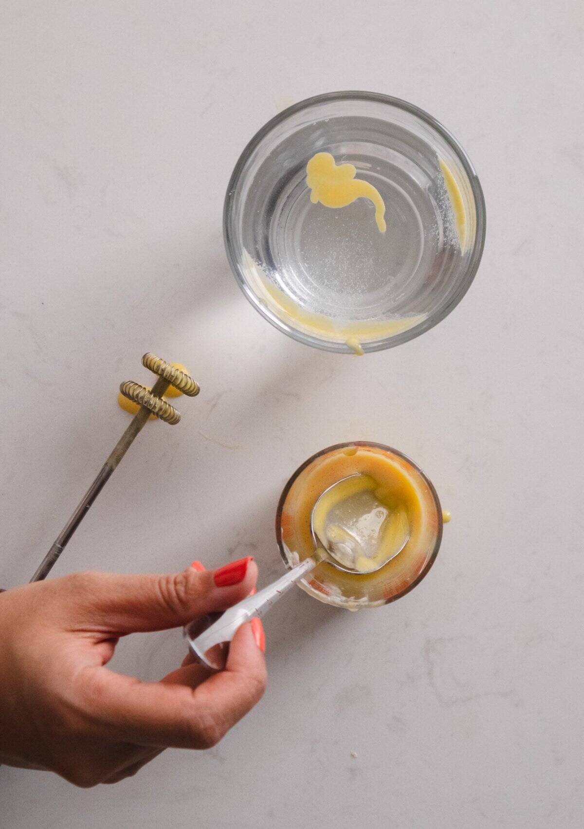 Egg topping for egg coffee floating at the top of a glass of water.