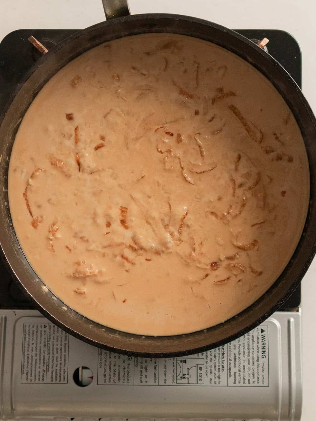 Creamy miso pasta sauce simmering in a black pan.