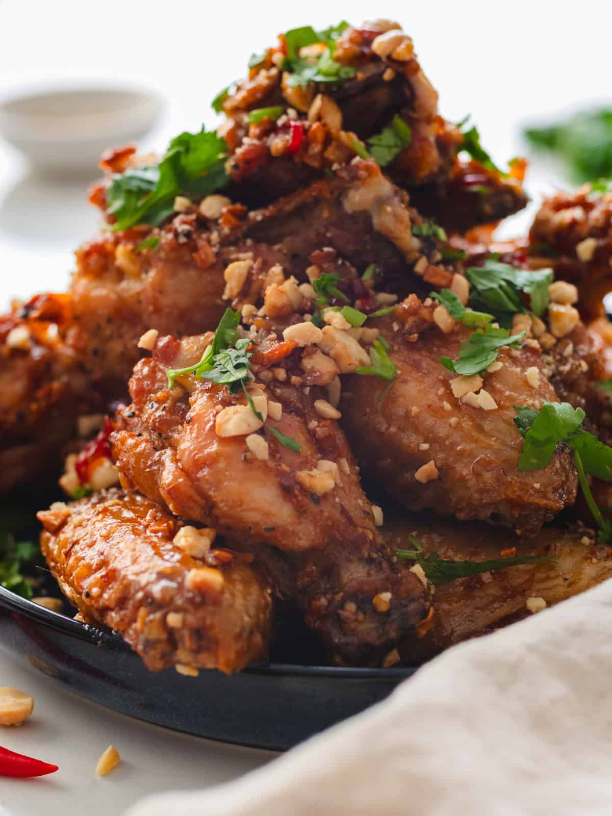Tamarind chicken wings on a blue plate with a white linen napkin.