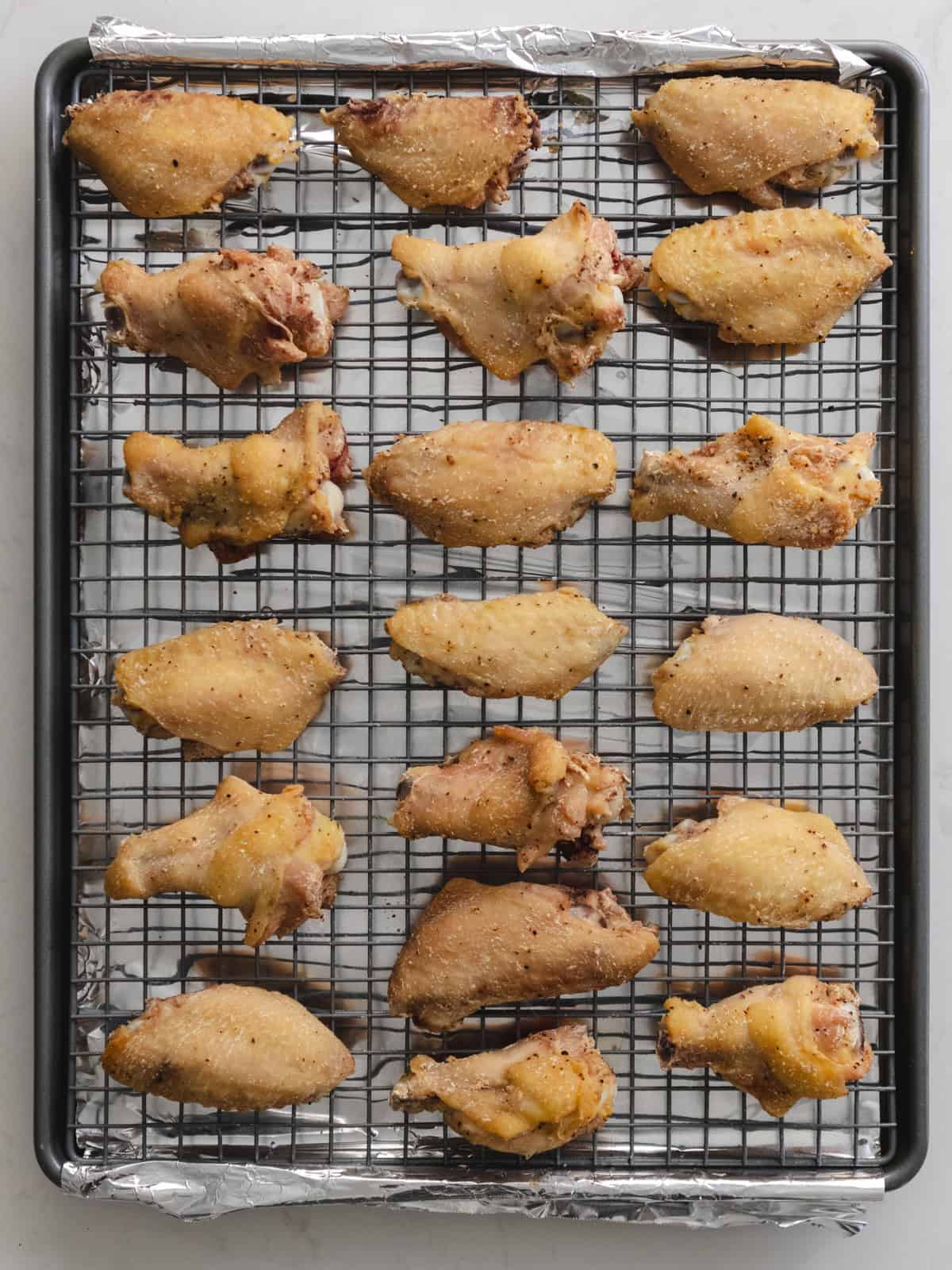 Once baked lightly golden brown chicken wings on a wire rack.