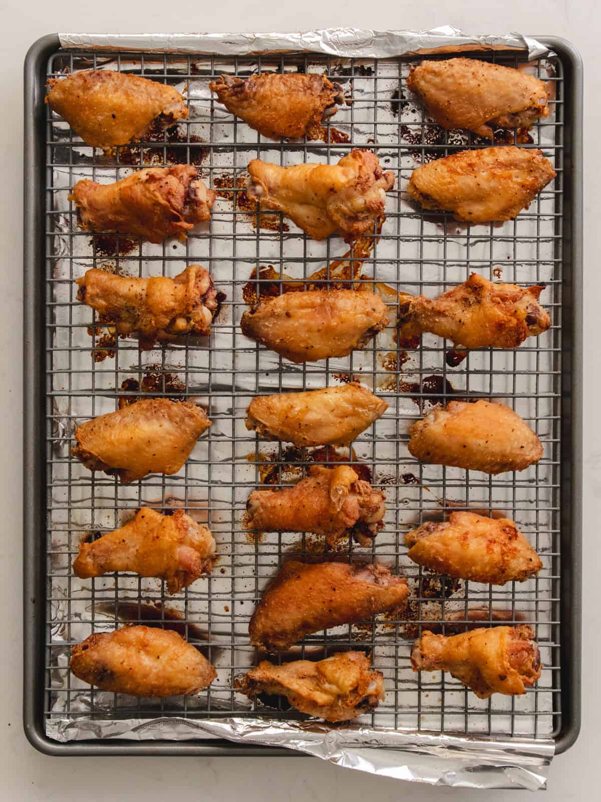 Second baked deep golden brown chicken wings on a wire rack.
