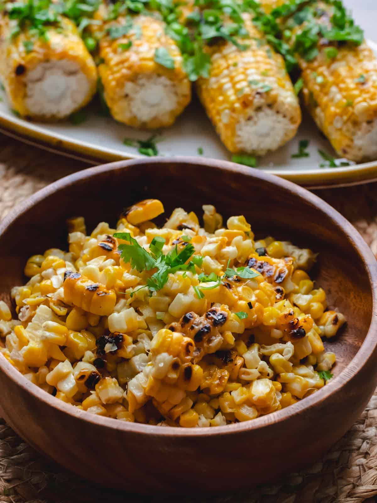 Roasted miso corn in a wooden bowl garnished with cilantro.