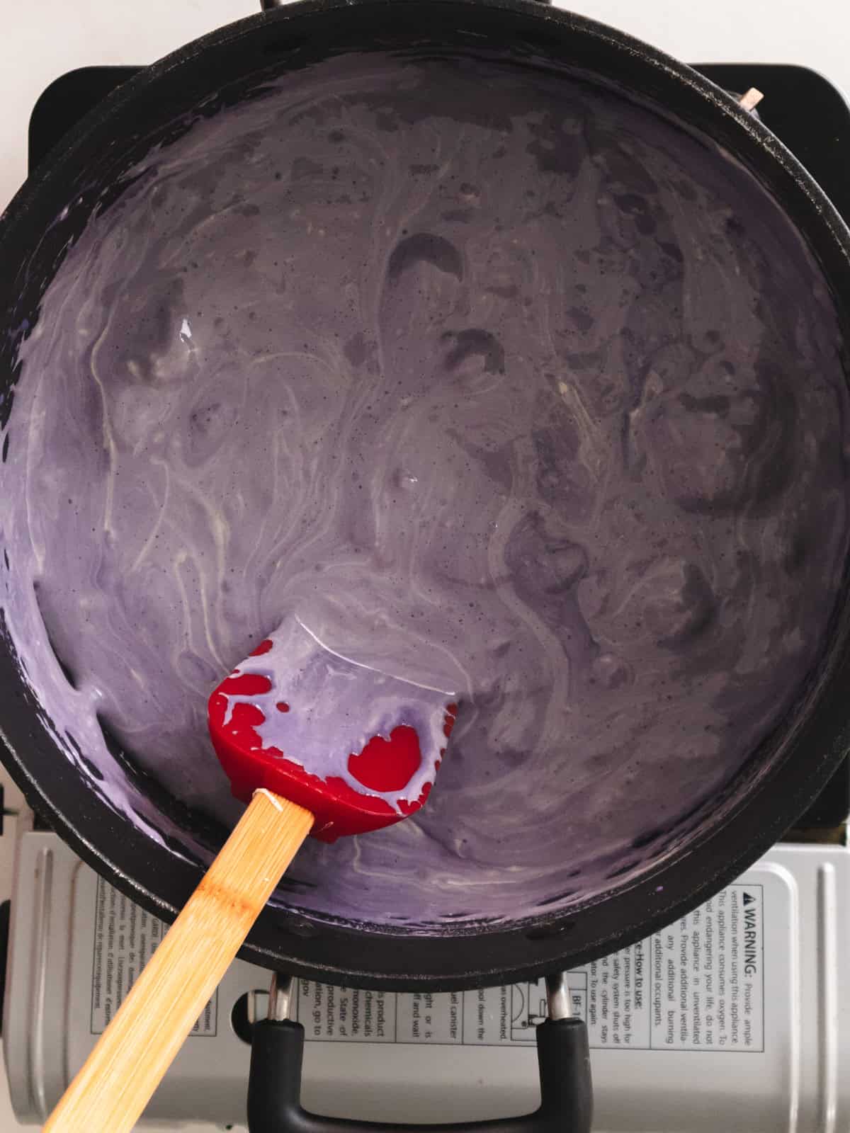 Melted marshmallows in a large pot mixed with taro protein powder.