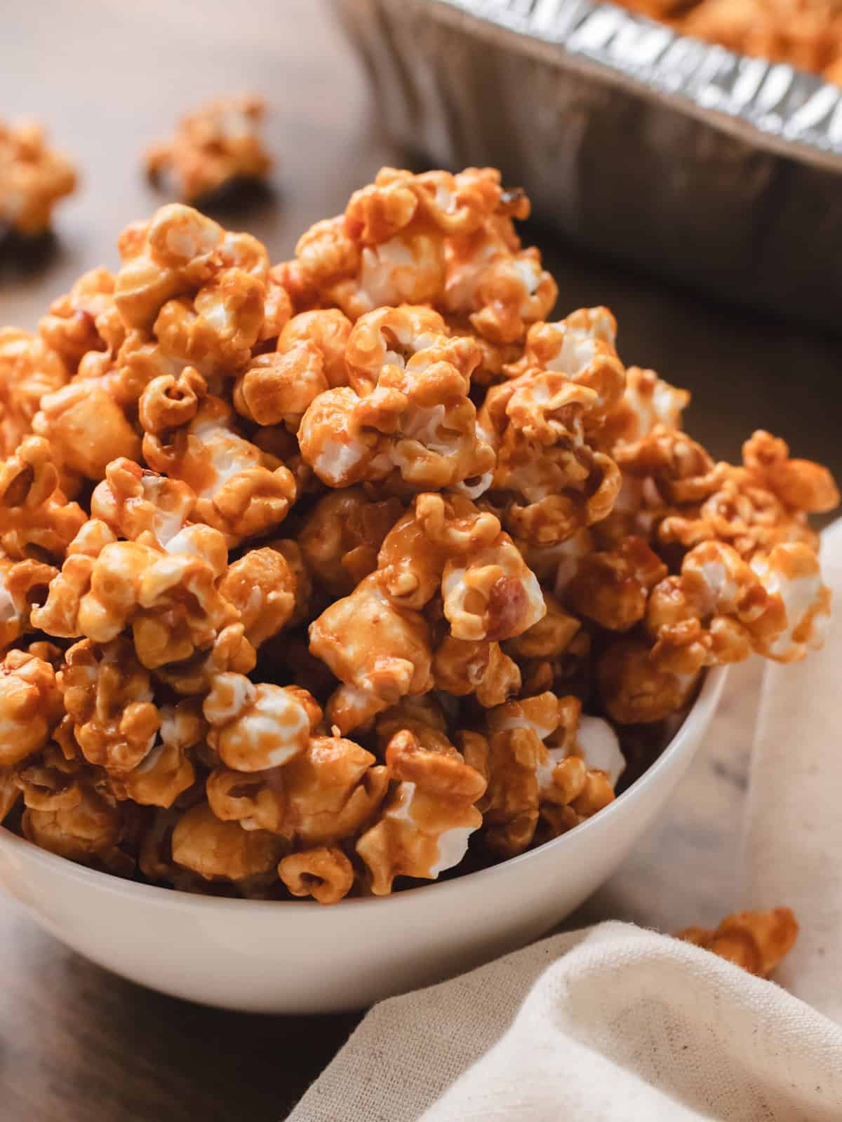Homemade miso popcorn in a white bowl on a wood table.