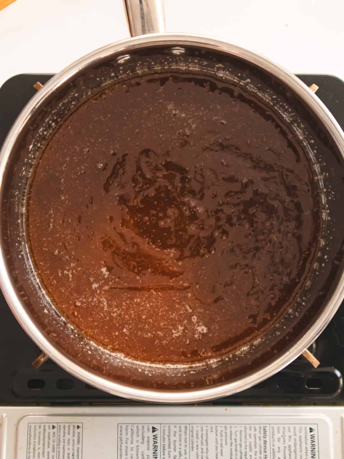 Miso caramel simmering in a stainless steel pot.